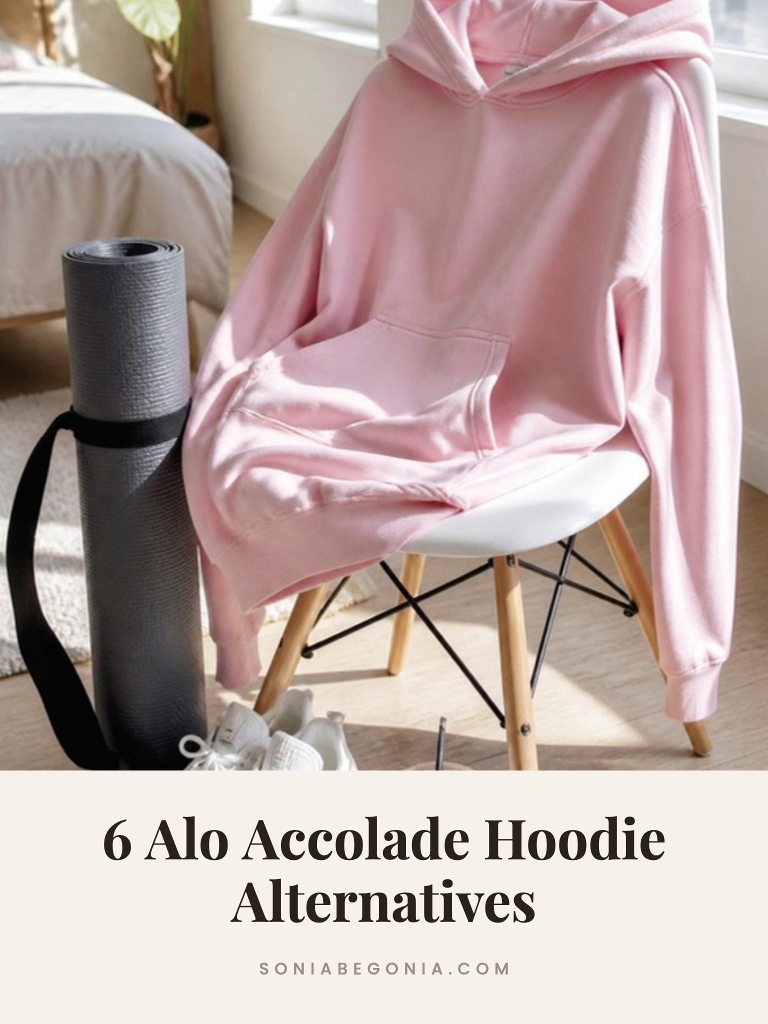 Alo Accolade hoodie alternatives: a pink oversized hoodie draped over a white chair next to a yoga mat