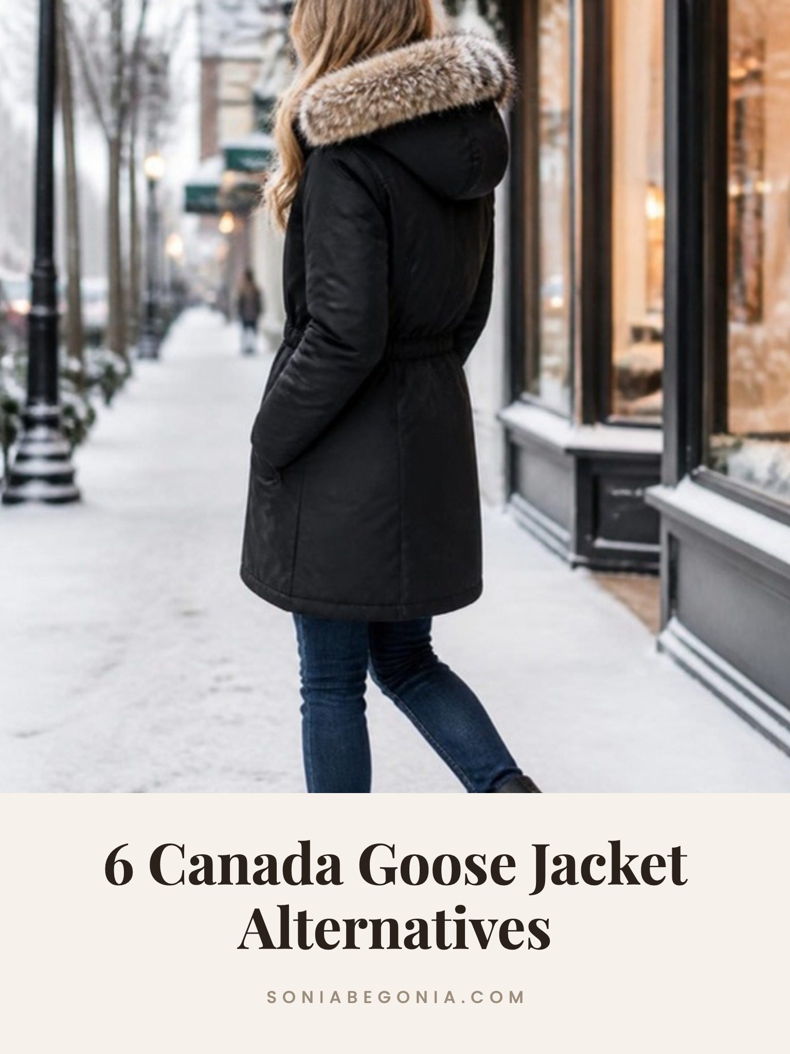 Canada Goose jacket alternatives: black parka with a faux fur trimmed hood worn with jeans and boots on a snowy city sidewalk