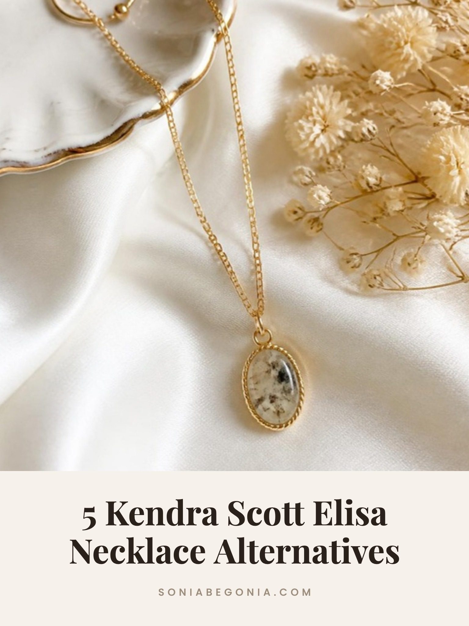 Kendra Scott Elisa necklace alternatives: a gold necklace with an oval stone pendant on cream silk