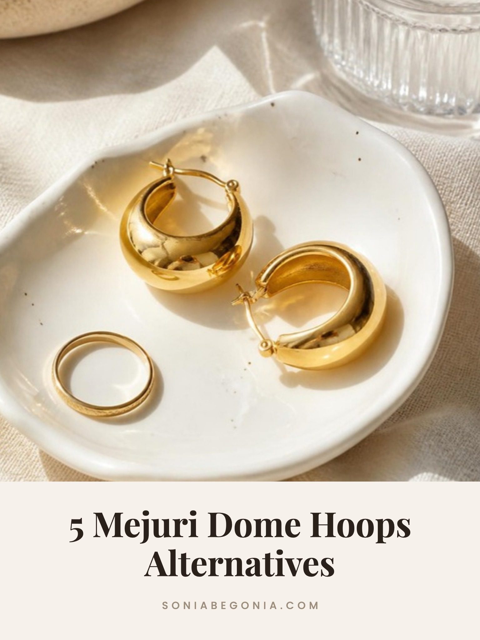 Mejuri dome hoops alternatives: chunky gold dome hoop earrings on a white dish