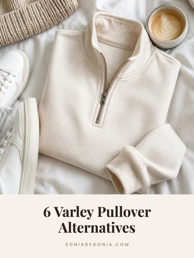 Varley pullover alternatives: an oatmeal half zip pullover folded on a white bed with sneakers and a latte